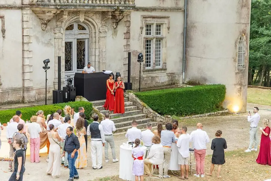 Vin d'honneur dans le jardin d'un château, invités et mariés