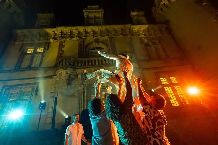 Le marié porté dans les airs par ses invités devant le château