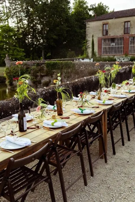 Table champêtre fleurie dressée dans le parc d'un domaine