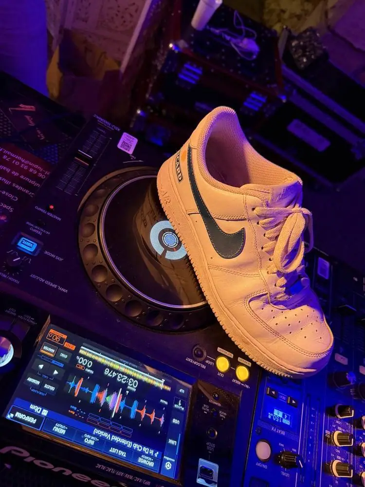 Détail de la régie DJ Pioneer de Loïc, avec une basket posée dessus