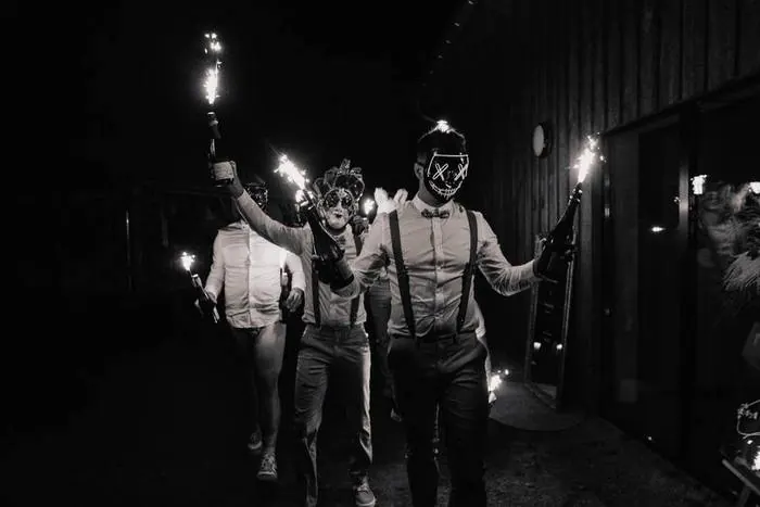 Entrée masquée des invités avec sparklers, en noir et blanc