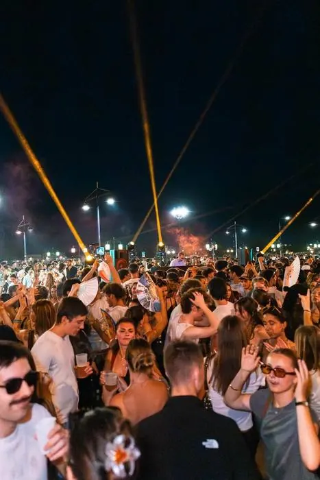 Invités dansant sous les lasers lors d'une soirée en extérieur