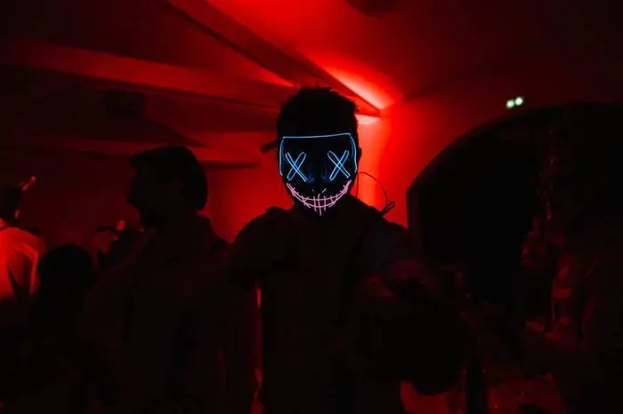 Invité portant un masque lumineux dans une ambiance rouge